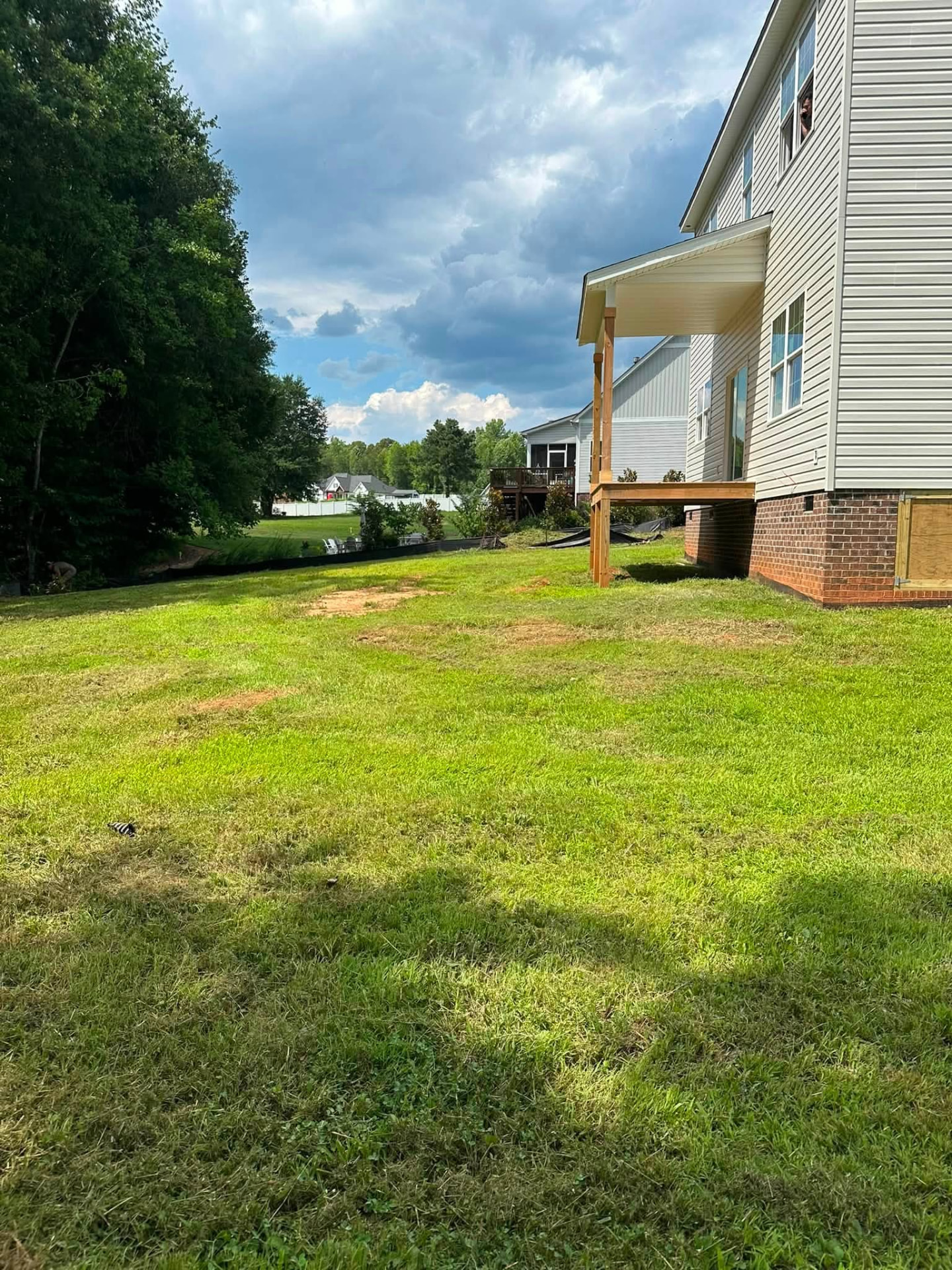 Freshly mowed backyard beside a new home